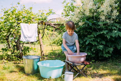 Side view of boy standing by plants