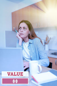 Young woman using smart phone on table