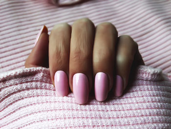 Close-up of woman with pink nail polish 