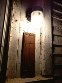 Low angle view of illuminated lamp on old building