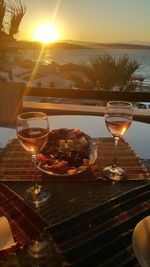 High angle view of wine glass on table against sky during sunset