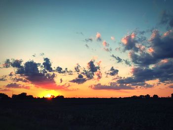 Scenic view of silhouette field against sky during sunset