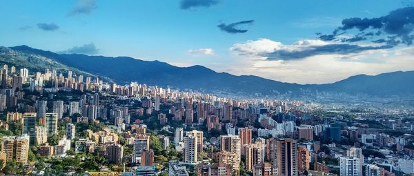 Aerial view of city against cloudy sky