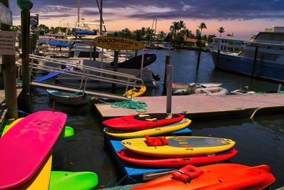 Boats moored at harbor against sky