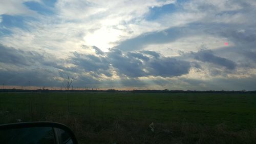 Scenic view of grassy field against sky