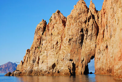 Panoramic view of rock formations in sea against clear sky