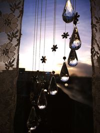 Close-up of electric hanging against sky