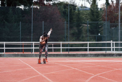 Full length of woman with umbrella standing on field