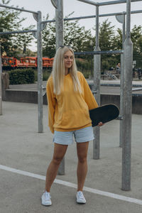 Full length of young woman standing in city