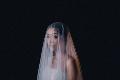 Young woman standing against black background