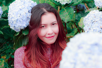 Mid adult woman by flowering plants in park