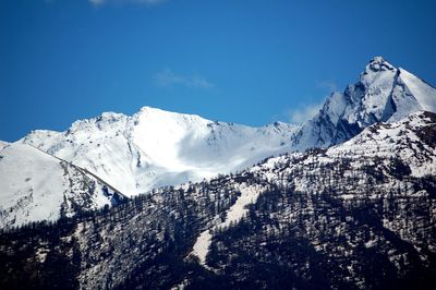 Scenic view of snowcapped mountains against clear blue sky