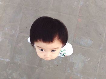 Directly above shot of baby girl standing on tiled floor