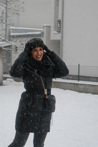 Portrait of young woman standing on snow