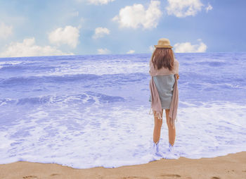 Rear view of man looking at sea against sky