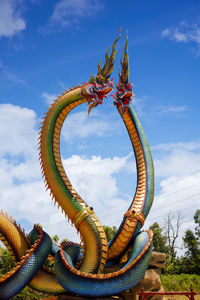  low angle twin stucco painted as a large serpent at pra kai keaw wang nakin,  udon thani, thailand.