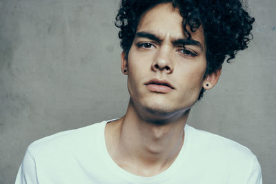 Portrait of young man against wall