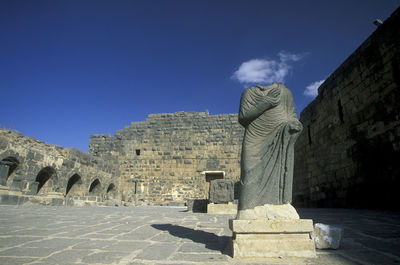 Low angle view of old ruins against clear blue sky