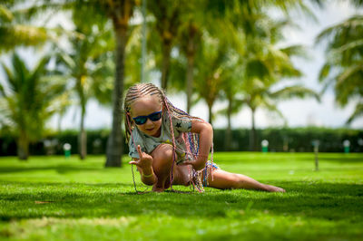 Rear view of girl wearing sunglasses on grass