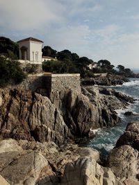 Rock formations by sea against sky