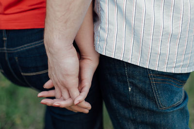 Midsection of couple holding hands