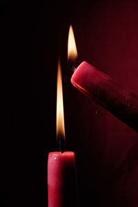 Close-up of lit candles in darkroom