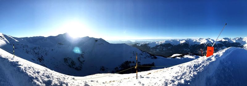 Scenic view of snowcapped mountains against blue sky