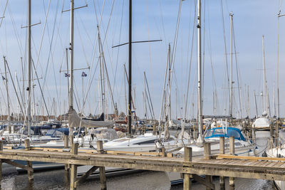 Sailboats moored at harbor