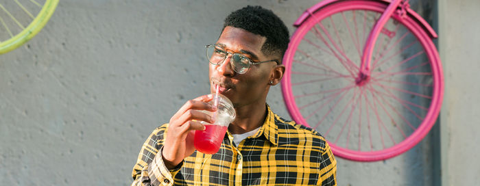 Young man with bicycle against wall