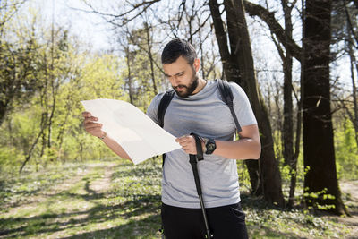 Young man standing against wall in forest