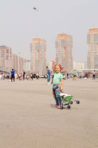 Girl with toys standing on street