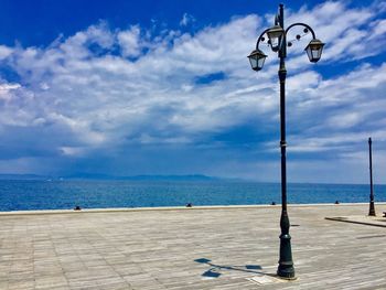 Street light on beach against sky