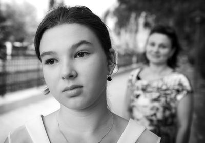 Close-up of girl with mother standing in background