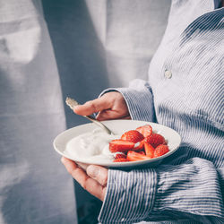 Midsection of man holding ice cream in bowl