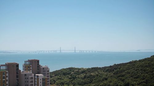 Bridge over sea against clear sky