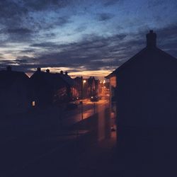 Buildings against cloudy sky at dusk