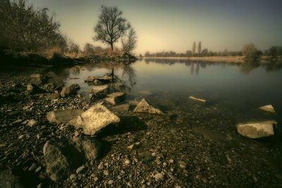 Scenic view of lake against sky at sunset