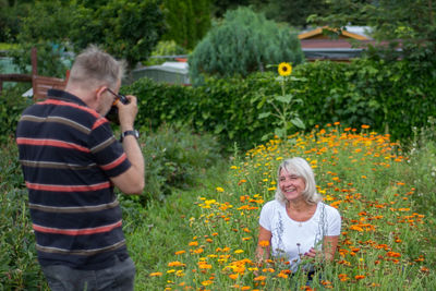 Portrait of smiling woman holding flowering plants