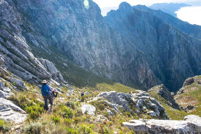 Rear view of person walking on rocks