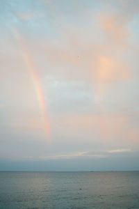 Scenic view of rainbow over sea against sky