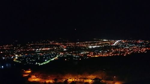 High angle view of illuminated buildings against sky at night