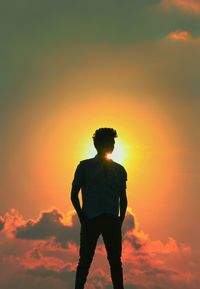 Rear view of man standing against sky during sunset