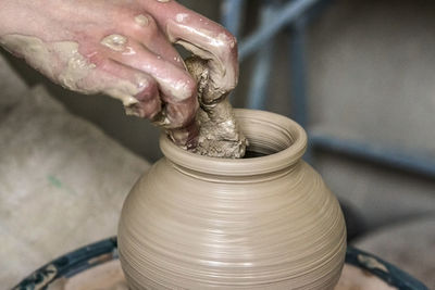 Making crock crude wet close-up. man hands and tool making clay jug macro. the sculptor