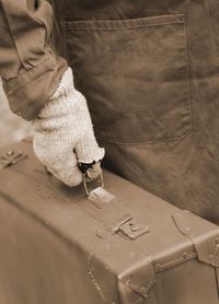 Midsection of man holding suitcase