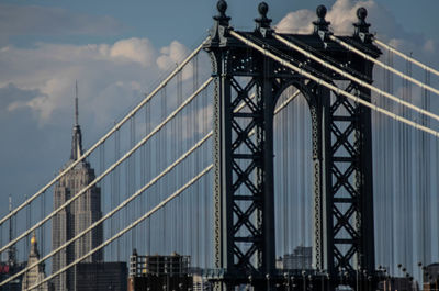 Low angle view of suspension bridge against sky