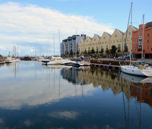 Boats in harbor with buildings in background