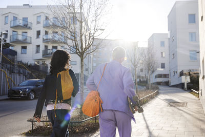 Rear view of female friends or gay couple walking together