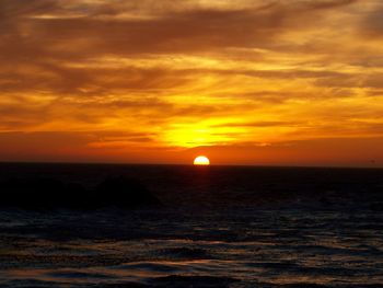 Scenic view of sea against romantic sky at sunset