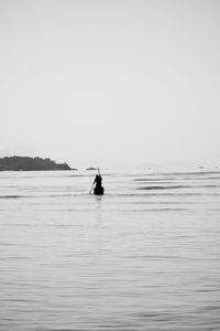 Man on sea against clear sky