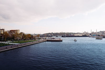 Scenic view of river by buildings against sky